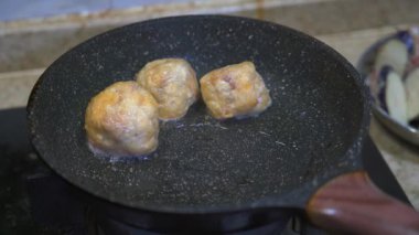 Bir şef tavada doldurulmuş sebze, biber ve avokado kızartıyor.