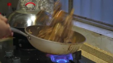 Mutfakta bir şef ördek eti pişiriyor, soslu ördek etini kızartıyor.