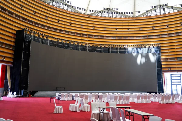 Equipment dining table and big screen in large indoor banquet hall