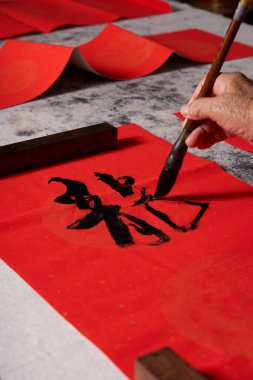 Eski bir kaligraf Çin Ejderha Yılı 'nda çiftler yazar. Çeviri: Ejderha Yılı' nda iyi şanslar, tüm dilekleriniz gerçek olsun..