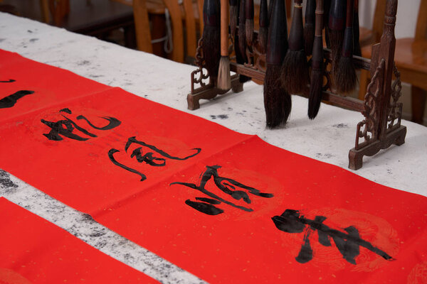 An old calligrapher writes couplets during the Chinese Year of the Dragon.Translation: Golden Dragon wishes you good luck in the new year.