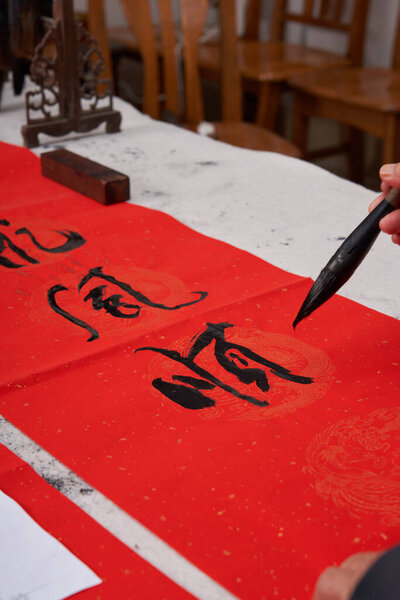 An old calligrapher writes couplets during the Chinese Year of the Dragon.Translation: Golden Dragon wishes you good luck in the new year.