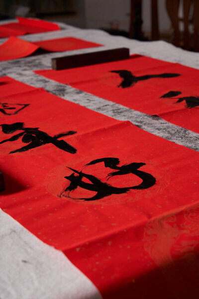 An old calligrapher writes couplets during the Chinese Year of the Dragon.Translation: Good luck in the Year of the Dragon, may all your wishes come true.