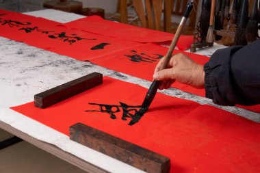 Eski bir kaligraf Çin Ejderha Yılı 'nda çiftler yazar. Çeviri: Bahar ve Ejderha Yılı' nda iyi şanslar.