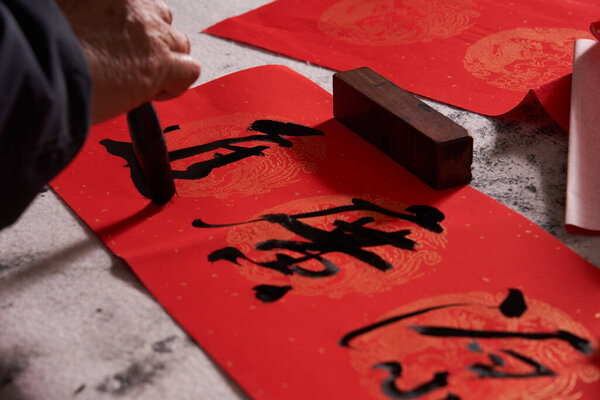 An old calligrapher writes couplets during the Chinese Year of the Dragon.Translation: The auspicious energy brings auspiciousness and the wealth is abundant.