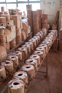 Geleneksel bir Çin çömlek fabrikasında kilden embriyolar ve kalıplar düzgünce istiflenmiş.