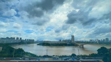 Nanning, Guangxi, Çin 'deki Yong Nehri boyunca binaların ve gökyüzünün hızlandırılmış fotoğrafları.