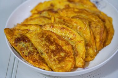 Bir tabak lezzetli kızarmış yumurtalı böreğin yakın çekimi.