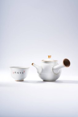 Geleneksel Çin çaydanlığı ve çay fincanı beyaz arka planda, çay seremonisi aletleri