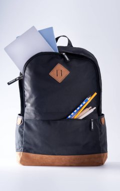 Beyaz bir arka planda bir öğrencinin okul çantasının yakın çekimi.