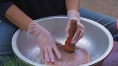 Bir şef domuz göbeğini delmek için iğne tahtası kullanıyor. Pişmiş domuz eti için hazırlanıyor..