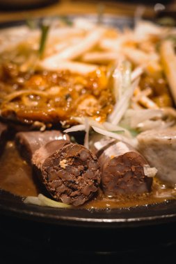 Bol soslu haşlanmış kan sosisi.