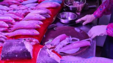 Meşgul bir sebze pazarında alışveriş yapmak, patronun bakması için deniz mahsulleri mürekkep balığı toplamak.