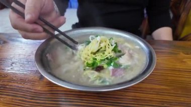 Bir müşteri Çin, Guangxi, Nanning 'deki bir erişte dükkanında taze domuz Yi mein yiyor.