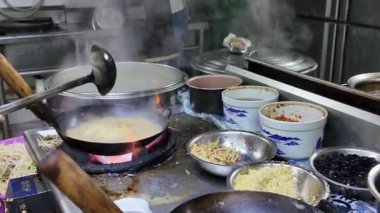 Bir şef Çin, Guangxi, Nanning 'de bir erişte dükkanında taze domuz Yi mein pişiriyor.