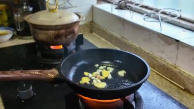 Bir şef kızartma tavasında kuzu pişiriyor.