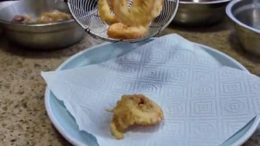 Bir şef tavada kalamar halkaları kızartıyor.