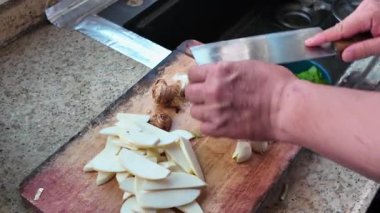 Sarımsak soyan ve doğrayan bir şef.