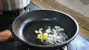 Bir şef tavada yılan balığı filetosu pişiriyor.