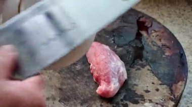 Bir şef domuz eti ve kıyma kesiyor.