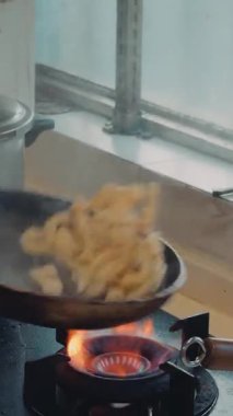 Çinli bir şef kızartma tavasında domuz derisi pişiriyor.