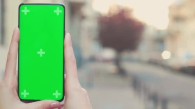 City Street 'in dışında Chroma Key Smartphone kullanan güzel kadın. Yeşil Ekran Cep Telefonu kullanan kadın. Omuz statik orta boy yakın çekim üzerinde. Yüksek kalite 4k görüntü