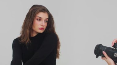 Stüdyoda çekilen bir fotoğraf çekiminde profesyonel bir fotoğrafçıya poz veren genç ve güzel bir kadın model. Yüksek kalite 4k görüntü