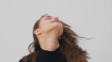 Beyaz arka planda gülümseyen genç bir kadın. Stüdyoda gülümseyen mutlu kızın portresi. Moda mankeni gülüşünü kapat. Yüksek kalite 4k görüntü