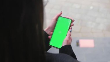 Kadın ellerini kentin arka planında yeşil ekranlı dikey bir cep telefonuyla kapat. Akıllı telefondan Chroma tuşu modeli. - Evet. Yüksek kalite 4k görüntü