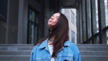 Genç, güzel, esmer, beyaz bir kadın, şehrin merkezinde. Uçan saçlı çekici bir manken. - Evet. Yüksek kalite 4k görüntü