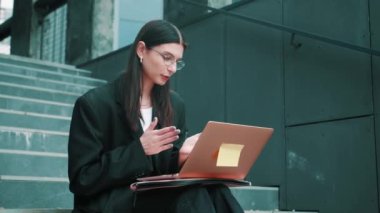 Kafkasyalı sıradan bir iş kadını laptopuyla dışarıyı yavaş çekimde arıyor. Sıradan, iş, güven ve iletişim. Yüksek kalite 4k görüntü