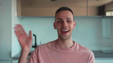 Gülümseyen yetişkin beyaz adam vlogger kamera konuşmasına bakıyor canlı video konferans görüşmesi yapıyor blogu kaydediyor evdeki kanepeye oturuyor, webcam görüntüsünü kapatıyor, video kaset konseptini kapatıyor. Yüksek kalite 4k görüntü