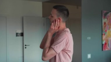 Genç, kaygısız, beyaz kulaklık takan bir adamın özgün çekimi evde bir mutfakta çılgınca dans eden ve müzik dinleyen bir adamı dinlemekten zevk alıyor. Yüksek kalite 4k görüntü