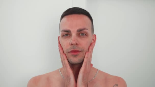 年轻的白人男子每天早上做护肤工作 用手指按摩脸部 自我照顾的概念 男人的美丽 高质量的4K镜头 — 图库视频影像