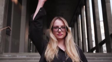 Genç ve çekici bir kadın sokakta dururken elini sıkıca kavrayıp elini kaldırıyor. Milenyum kız eylemcileri hareketi destekliyor ve insan hakları için savaşıyor. Protesto kavramı. Yüksek kalite 4k