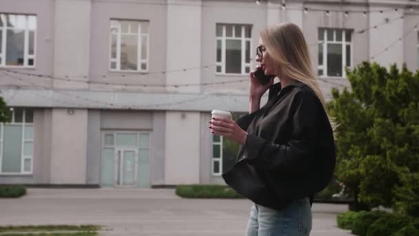 Kentin Şehir Caddesinde Elinde Kahve Fincanı Olan Telefonuna Cevap Veren — Stok video