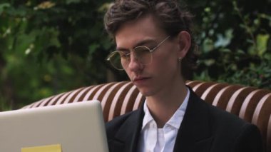 Ofisin dışında çalışan stresli ve üzgün, laptoplu, beyaz bir adamı kapatın. İş adamının portresi kötü haberlerle dolu bir e-posta alıyor ve kenarda oturmaktan bıkmış hissediyor. Yüksek kalite 4k