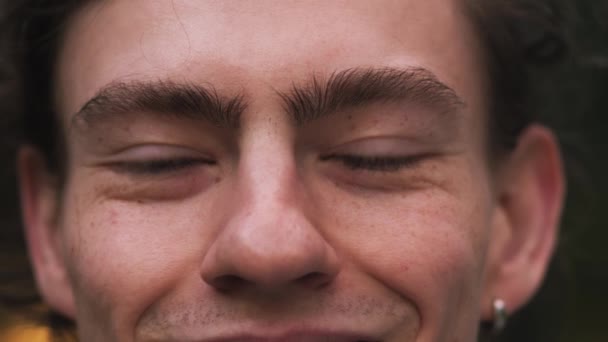 Крупным Планом Портрет Молодого Человека Открывает Глаза Смотрит Камеру Улице — стоковое видео