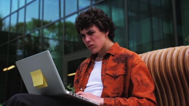 おい何だ 怒りの感情 近代的なオフィスの近くの屋外で働いている眼鏡の男とコンピュータの画面を見て 高品質4K映像 — ストック動画