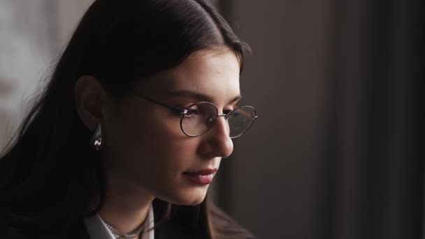 ラップトップで働く疲れた女性の近くに オフィスでコンピュータを使用して忙しい反射で眼鏡をかけた女の子 高品質の4K映像 — ストック動画