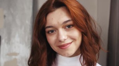 Kafkasyalı güzel bir kadının mutlu bir şekilde kameraya bakıp başarılı bir yaşam tarzının keyfini çıkardığı portresi. Modern ev hayatı konsepti. Yüksek kalite 4k görüntü