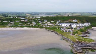 Çoğu insan boş zamanlarını İrlanda 'nın Inchydoney plajında geçirir. Yazın güzel İrlanda kıyıları, İHA videosu. Deniz burnu ve kocaman kumlu bir plaj. Popüler bir İrlanda tatil köyü.
