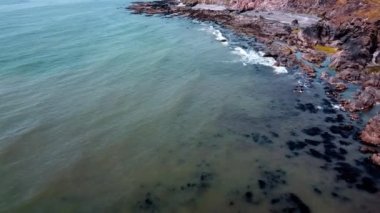 Kıyıdaki kayalar, deniz. Deniz manzarası, Atlantik Okyanusu. Deniz suyu drone videosu.