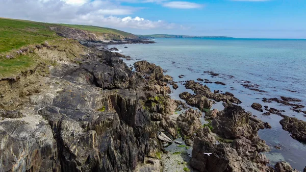The rocky coast of the island of Ireland. A rocky reef in the Celtic Sea. Beautiful coastline of northern Europe. Nature of Southern Ireland. Aerial photo.