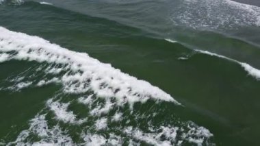 Atlantik 'in köpüren dalgaları, üst manzara. Suyun yüzeyinde beyaz deniz köpüğü, insansız hava aracı videosu. Deniz manzarası, sadece su..