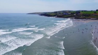 Birçok insan boş zamanlarını ünlü İrlanda plajı Inchydoney 'de geçirir. Yazın güzel İrlanda kıyıları, İHA videosu. Deniz manzarası ve kumsal..