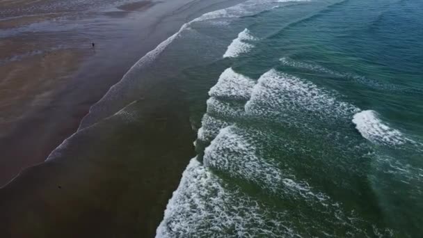 湿った砂と美しい潮の波と無人島のビーチ 波の上に白い海の泡 シースケープトップビュードローンビデオ 大西洋の表面の波 — ストック動画