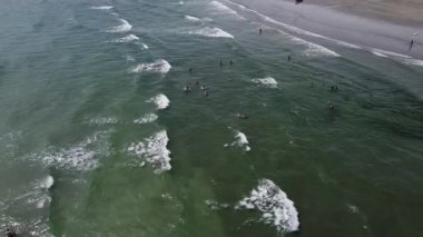 County Cork, İrlanda, Temmuz 2022. İnsanlar denizi sever. Güzel dalgalar ve köpük. Atlantik Okyanusu, üst manzara, insansız hava aracı videosu.