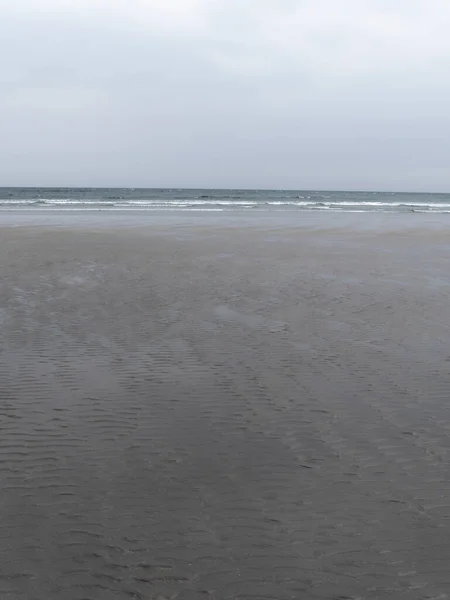 低潮时的凯尔特海海岸 凉爽的天气里 湿湿的沙滩 简约的海景 多云的天气 — 图库照片