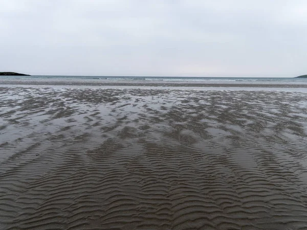 多云的日子里 在低潮的海滨湿透波浪的沙子 荒凉的海滨风景 严酷的天性 — 图库照片